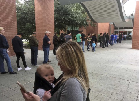 In this Oct. 22 photo, Megan Heckel of Plano holds her daughter Lily as they wait in line for early voting outside Maribelle M. Davis Library in Plano, Texas Photo: David Koenig, STF / AP