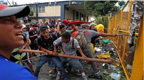 Immigrants facing police on Guatemala-Mexico border